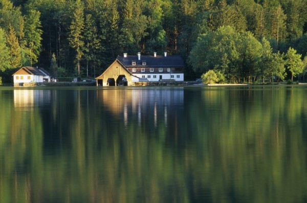 AUSTRIA, Oberosterreich, Mondsee, View across lake towards boat house and other building with