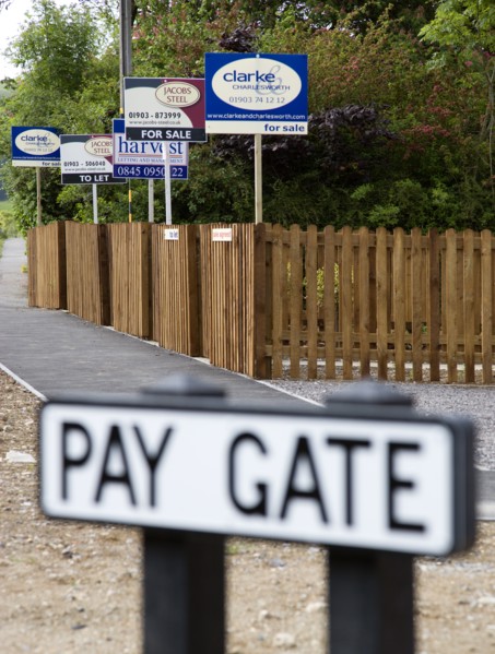 ENGLAND, West Sussex, Washington, To Let and For Sale signs on wooden fencing outside a newly built