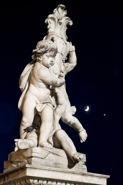 ITALY, Tuscany, Pisa, An illuminated statue in The Piazza del Duomo of cherubs holding a shield