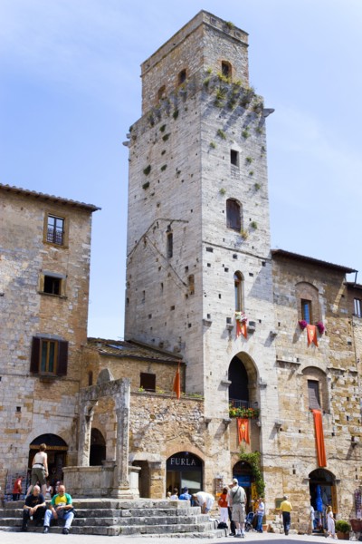 ITALY, Tuscany, San Gimignano, People gathering around the well in the Piazza della Cisterna with