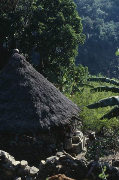 COLOMBIA, Sierra Nevada de Santa Marta, Ika, Ika man woman and child outside circular mud-wattle