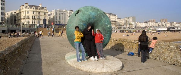 ENGLAND, East Sussex, Brighton, Tourists posing for photographs next to sculture on the seafront.