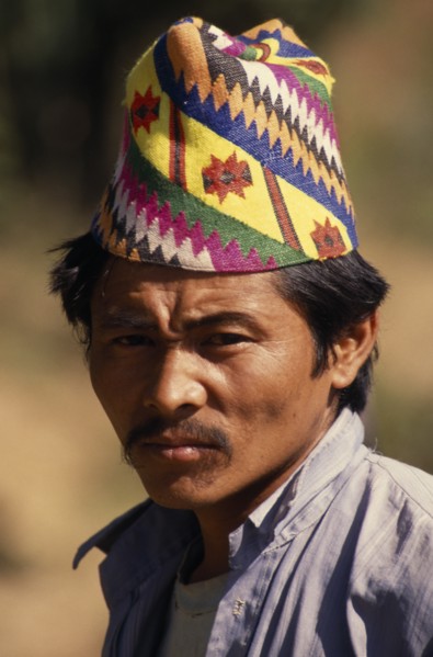 NEPAL, East, Chainpur, Head and shoulders portrait of a man wearing a Topi  traditional hat near