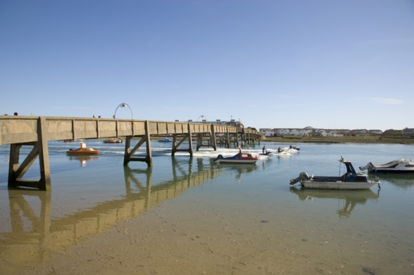 ENGLAND, West Sussex, Shoreham-by-Sea, Footbridge across the river Adur with waterskiers passing