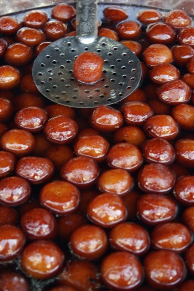 INDIA, Rajasthan, Udaipur, "Indian fried, sweet doughnuts in cooking pot of oil and syrup with
