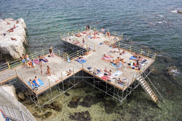 ITALY, Sicily, Syracuse, "Looking down on platform structure raised above rocky sea with steps to