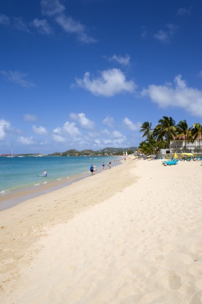 WEST INDIES, St Lucia, Gros Islet, Reduit Beach in Rodney Bay with tourists in the water and on the