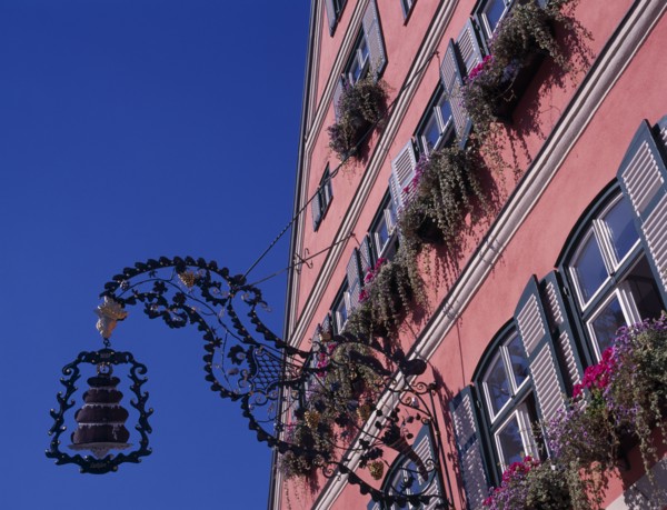 GERMANY, Bavaria, Dinkelsbuhl, Wrought iron cake sign for Cafe Rossimi attached to building facade