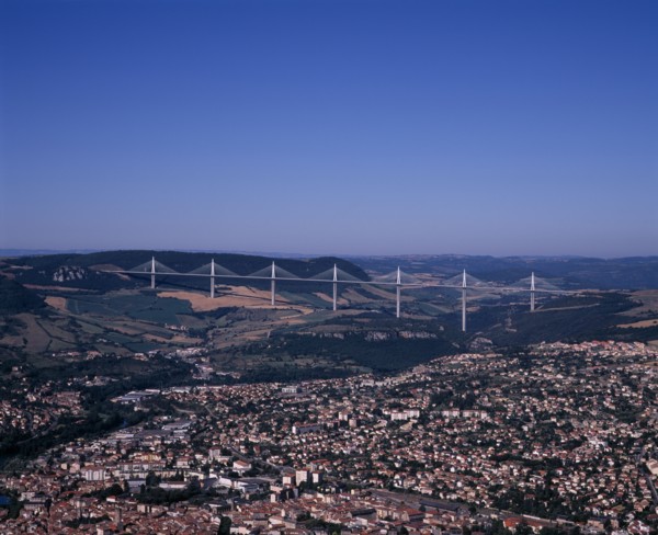 FRANCE, Midi-Pyrenees, Aveyron, Millau.  Cityscape with Millau bridge beyond which carries the A75