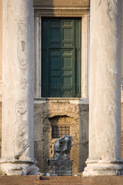ITALY, Lazio, Rome, Broken seated statue between two columns at the entrance of the Temple of