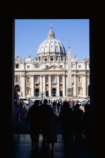 ITALY, Lazio, Rome, Vatican City Silhouette of tourists passing through an arch leading to the