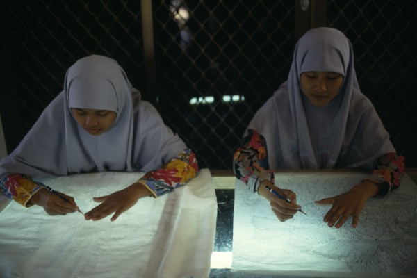 MALAYSIA, Crafts, Young women tracing floral patterns first on to paper then transferring them to