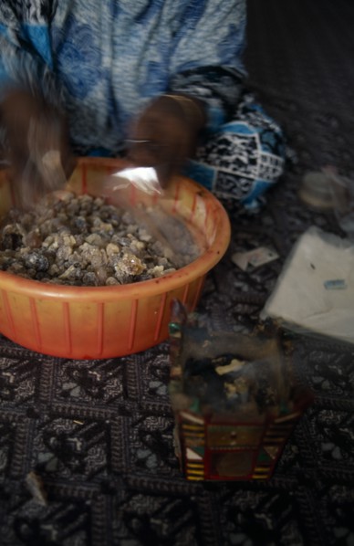 OMAN, Salalah, Trader bagging up frankincense for sale in souk.