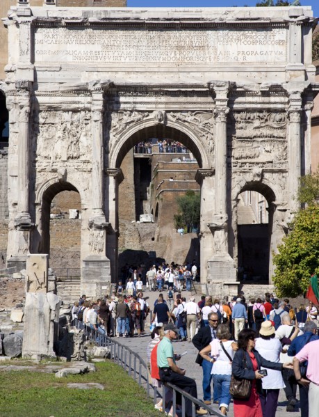 ITALY, Lazio, Rome, Tourists walking through the triumphal Arch of Septimius Severus from the Forum