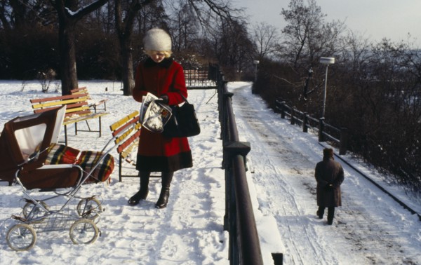 CZECH REPUBLIC, Prague, "Woman stopped to read newspaper in park in the snow.  She wears winter