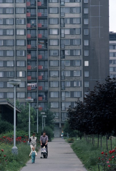 CZECH REPUBLIC, Prague, Multi-storey apartment block with young family walking along pathway in