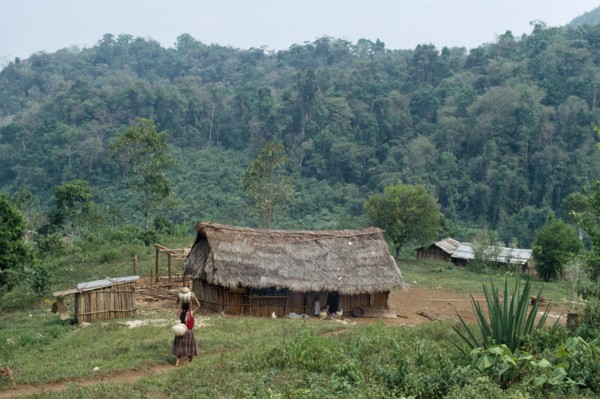 GUATEMALA, Alta Verapaz, Semuy, Q’eqchi Indian refugee village. Woman walking along path carrying a