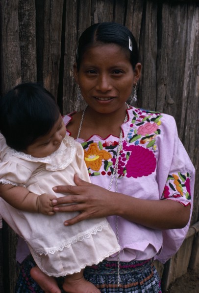 GUATEMALA, Alta Verapaz, Sacaak , Q’eqchi Indian mother wearing a traditional embroidered blouse