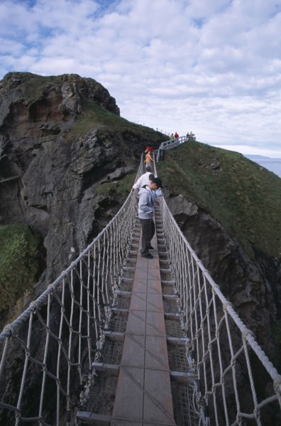 NORTHERN IRELAND, County Antrim, Ballintoy, Carrick-a-Rede Rope Bridge. Vistors walking over rope