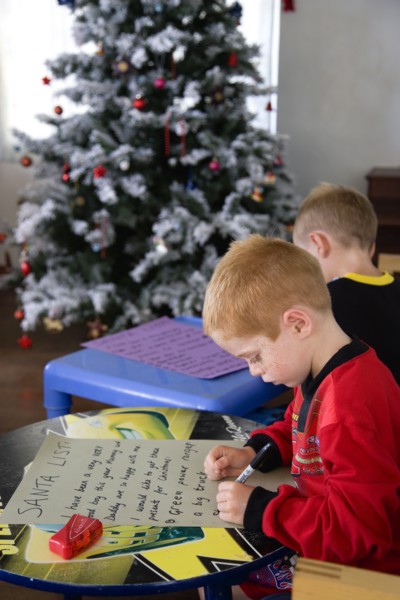 RELIGION, Festivals, Christmas, Two young left handed boys on Christmas Eve sitting down on a sofa