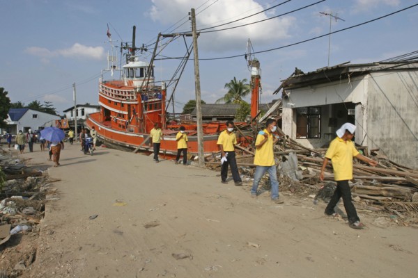 THAILAND, Phang Nga District, Nam Kem, "Tsunami. Volunteers and the locals walk past a fishing boat