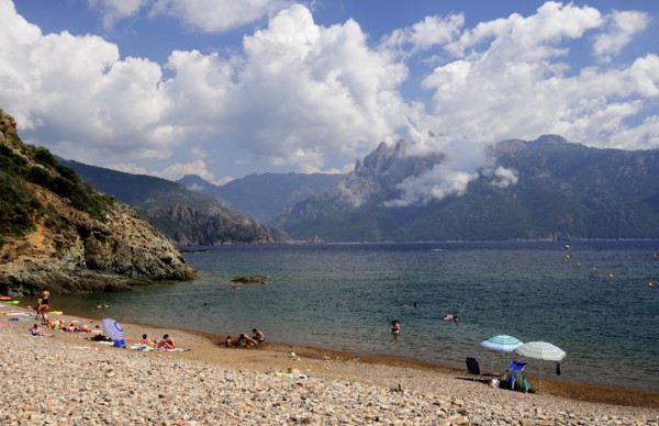 FRANCE, Corsica, Golfe Di Porto, "Plage De Bussaglia, shingle beach with umbrellas & bathers & Capo