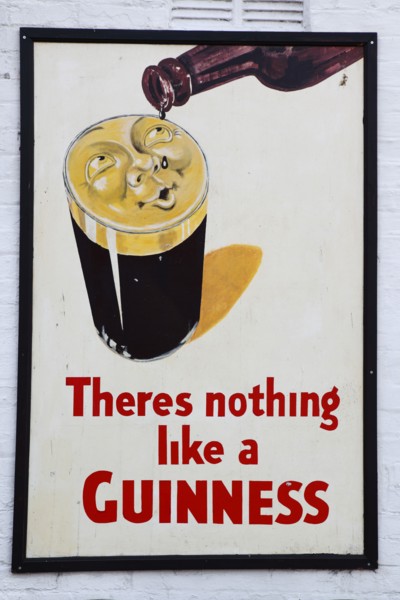 IRELAND, North, Belfast, "Bank Square, Old metal Guinness sign decorating the exterior Kelly's