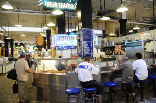 USA, California, Los Angeles, Central Market scene with people sat around a seafood bar.