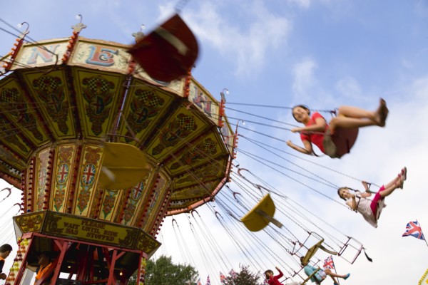 ENGLAND, West Sussex, Findon, Findon village Sheep Fair Children in motion riding on a swing