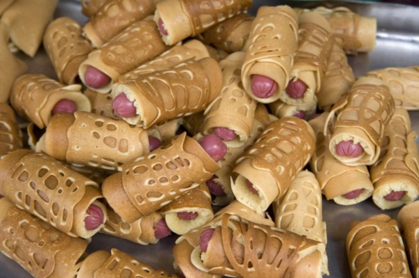 THAILAND, North, Chiang Mai, Close of small sausages wrapped in pancakes on sale in market. Pigs in