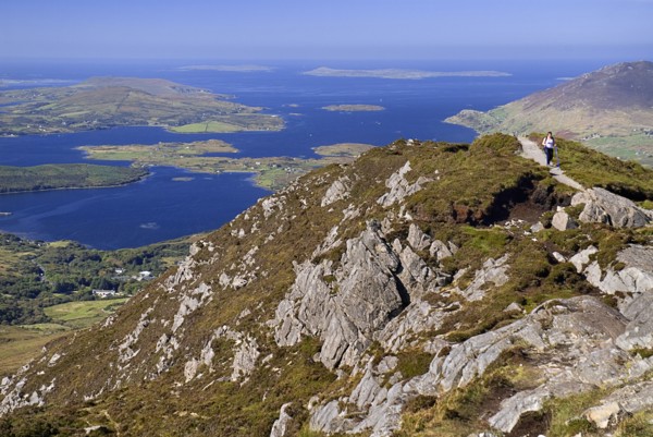 IRELAND, County Galway, Connemara, Diamond Hill, A hiker approaches the summit with Ballynakill