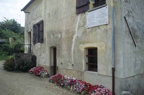 France, Ile de France, Coupvray, Marble commemorative plaque under a shuttered window on the wall