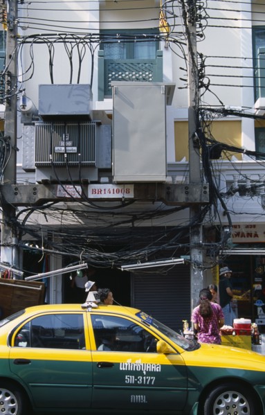 Thailand, Bangkok, Khao San Road, Overhead lectricity cables and transformers above pavement