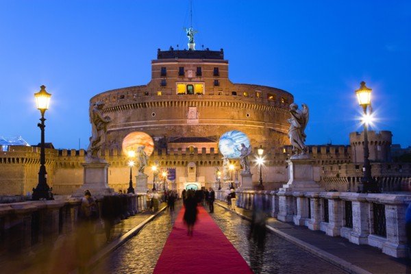 ITALY, Rome, Lazio, The fortress of Castel Sant Angelo illuminated at night with a red carpet laid