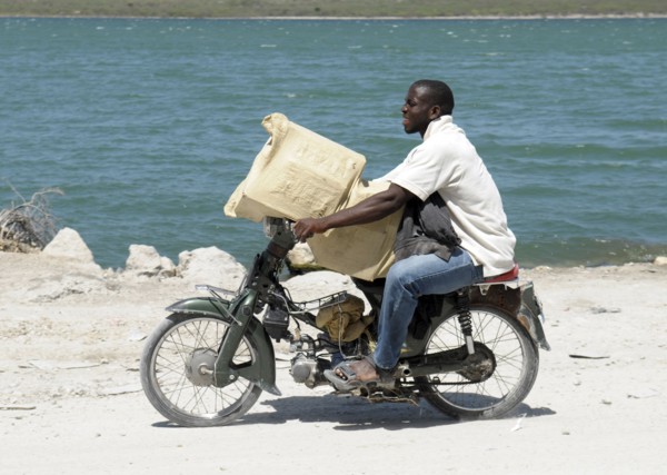 Haiti, Isla de Laganave, Man transporting goods on motorcycle.