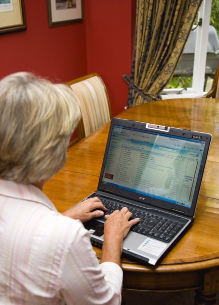 Industry, Computers, Laptop, Woman sitting at dining room table at home checking her email account