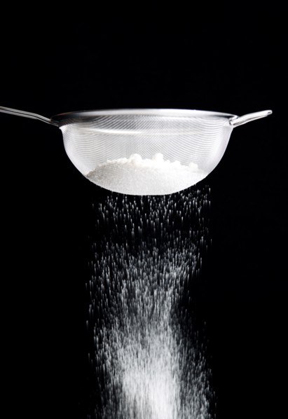 Food, Baking, Flour, White plain flour being siifted through a sieve against a black background.