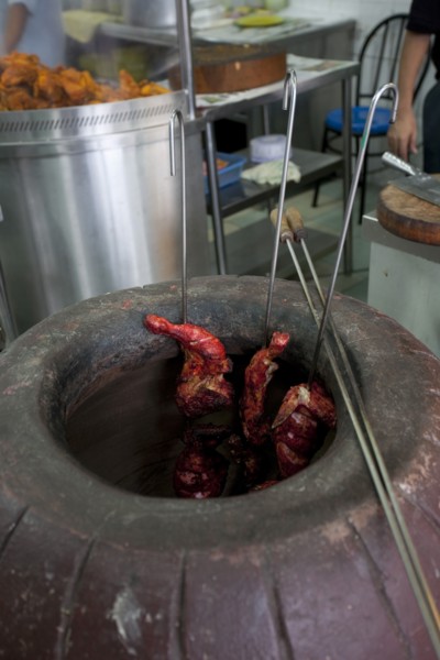 Malaysia, Kuala Lumpur, Skewered Tandoori chicken while being baked inside a Tandoor Oven at the