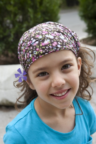 Greece, Macedonia, Thessaloniki, Head and shoulders portrait of a young smiling girl with a purple