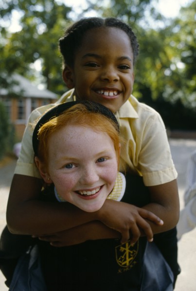 England, West Midlands, Birmingham, Smiling young girls in school playground with the white girl