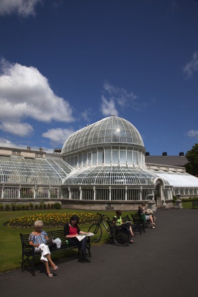 Ireland, Northern, Belfast, Botanic Gardens with people sat on benches outside the Palm House next