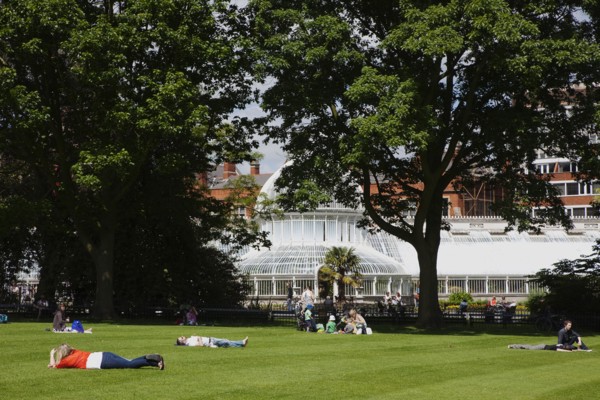 Ireland, Northern, Belfast, Botanic Gardens with people sat on benches outside the Palm House next