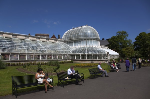 Ireland, Northern, Belfast, Botanic Gardens with people sat on benches outside the Palm House next