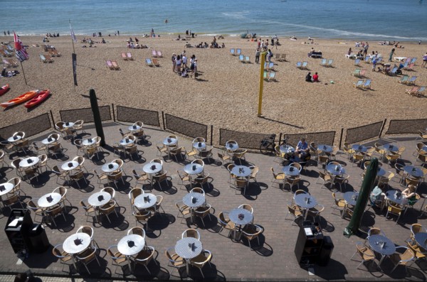 England, East Sussex, Brighton, view over tables outside seafront bar under the promenade.