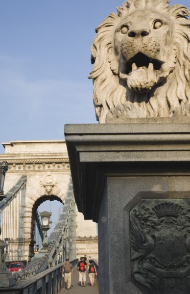 Budapest, Pest County, Hungary. Lion statue on Szechenyi Chain Bridge or Memory Bridge with passing