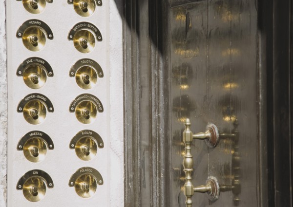 Venice, Veneto, Italy. Brass doorbells with nameplates on restored facade of apartment building