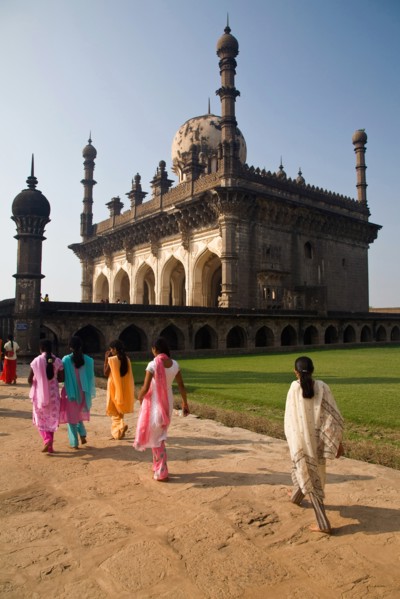 Bijapur, Karnataka, India. Tomb of Ibrahim Rauza with group of young women wearing brightly