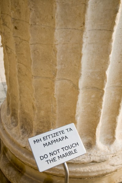 Athens, Attica, Greece. Acropolis Propylaea gate part view with Do not touch the Marble sign.