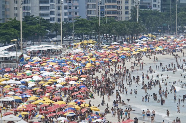 Rio de Janeiro, Brazil. Copacabana beach. Crowds on the beach and in the sea and multi-coloured