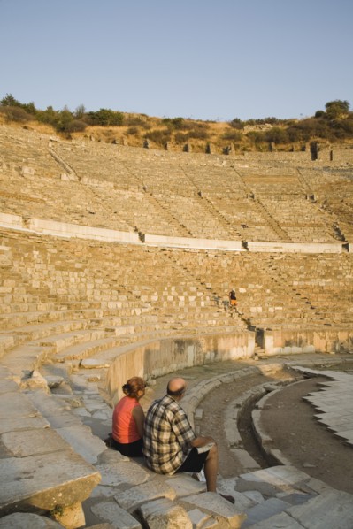 Selcuk, Izmir Province, Turkey. Ephesus. Tourist couple sitting in amphitheatre in the antique city